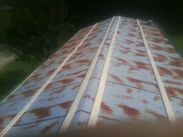 Rusted metal roof panels with new wood purlins before replacement — Storm Damage Roof Repair in Reidsville by Roofing Brothers