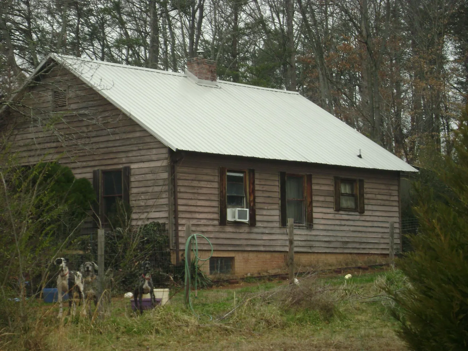 White metal roof on an old wood sided farmhouse, from a Metal Roof Installation job in Reidsville